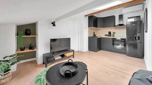 A modern apartment with a living area, kitchen, and dining space. - Le Blackwood (Mazamet)