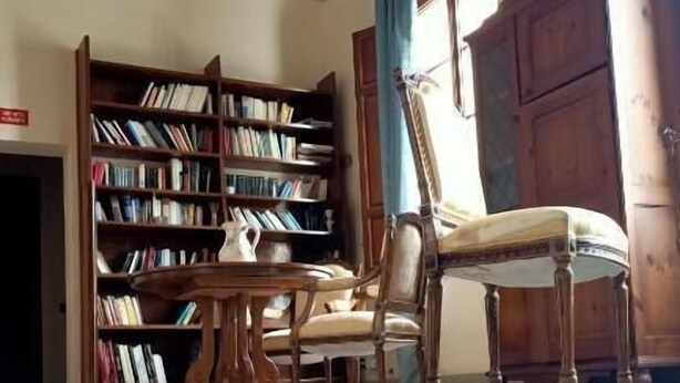 Une pièce comprenant une grande bibliothèque en bois, une chaise en bois et un meuble.