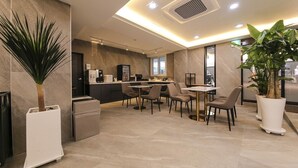 A modern dining area with a kitchen in the background, featuring a bar and seating.