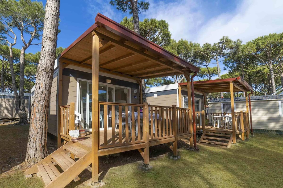 Una casa móvil con terraza de madera y porche cubierto.