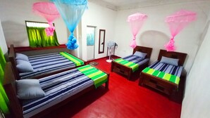 A room with four single beds, a standing fan, and mosquito nets. - Sewana Guest INN (Wellawaya)