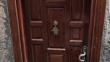 A wooden door with a metal handle and a brass knocker.