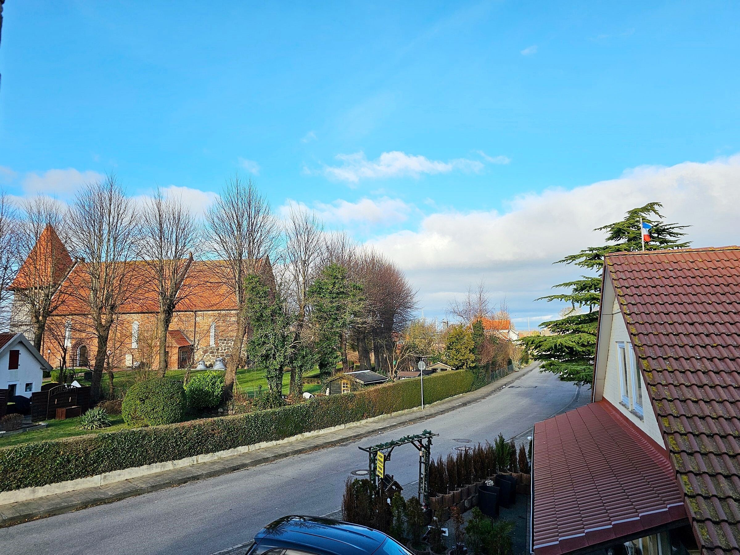 A street view with a church, residential buildings, and a clear sky.