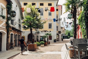 Una calle adoquinada con mesas al aire libre, un café y un edificio con un cartel que dice "Gosse".