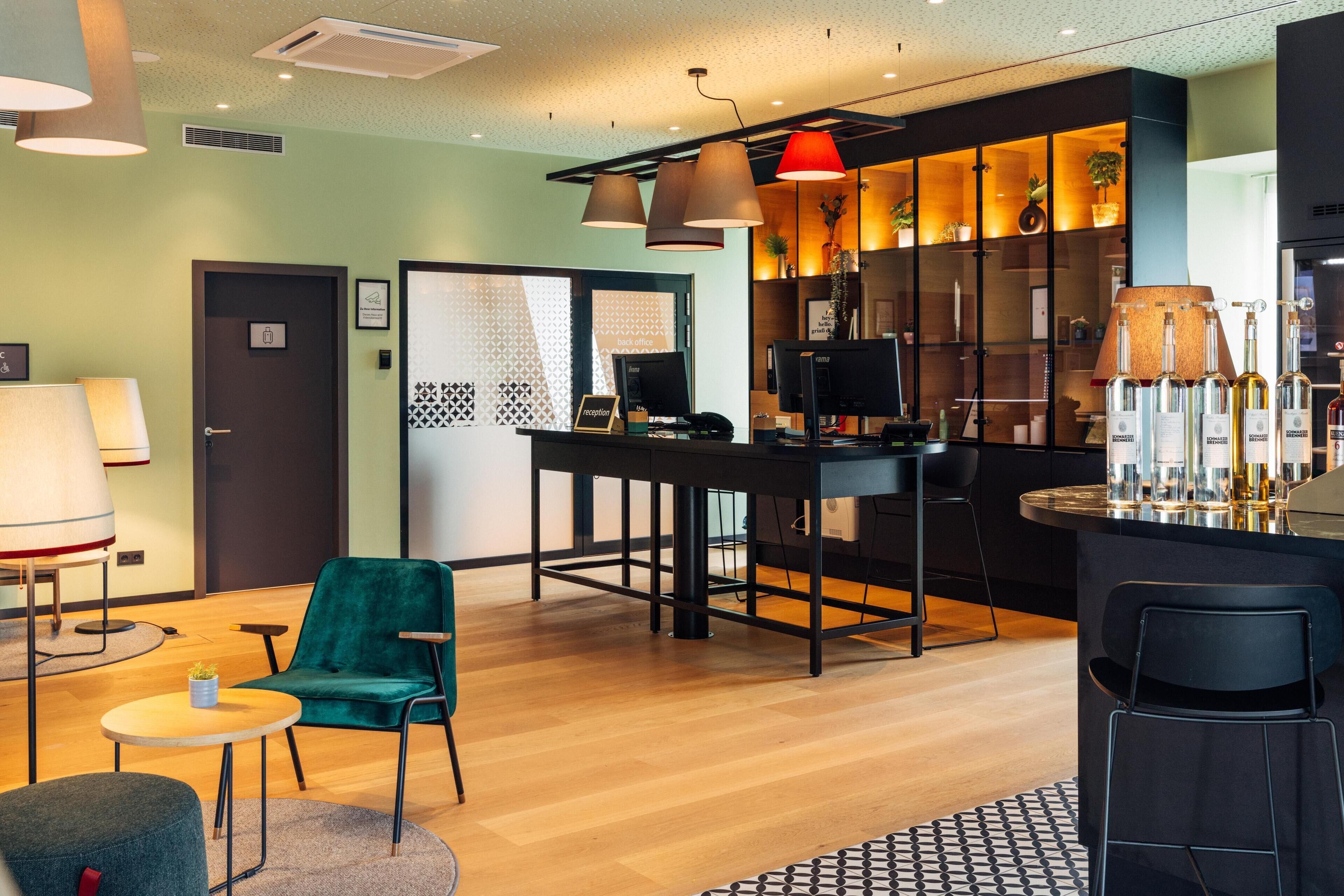 Un moderno vestíbulo de hotel con mostrador de recepción, zona de estar y bar.