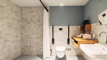 Un baño moderno con inodoro, lavabo y zona de ducha.