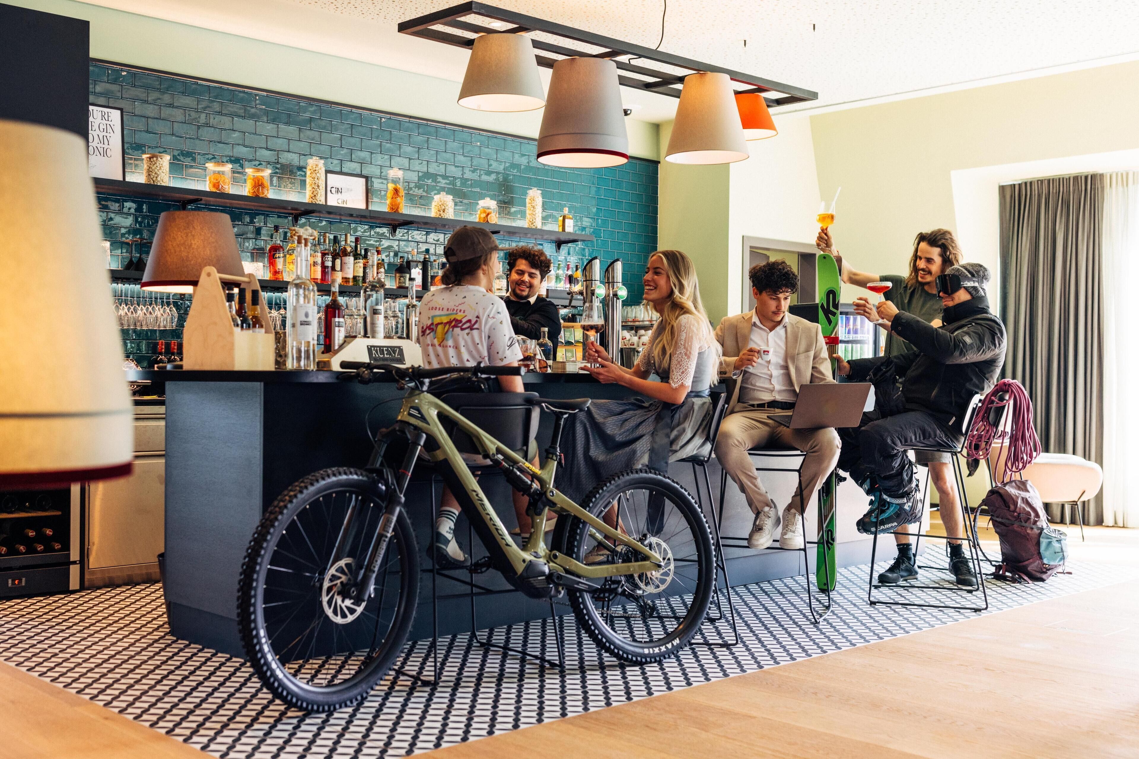 Zona de bar con mostrador, estantes con botellas y una bicicleta.