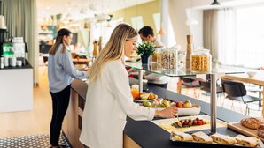 A breakfast buffet with various food items and a coffee station in a modern hotel setting. - harry's home Lienz hotel & apartments (Lienz)