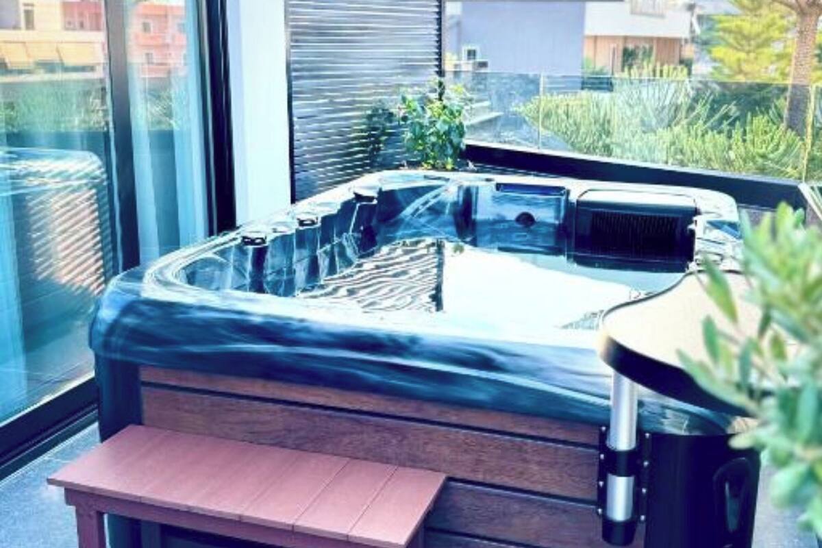 A hot tub with a wooden bench in a modern outdoor setting.