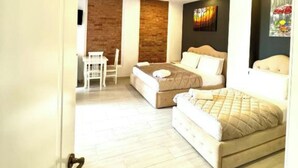 A bedroom with two beds, a desk, and a chair. - Hotel Joni Premium  (Ksamil)