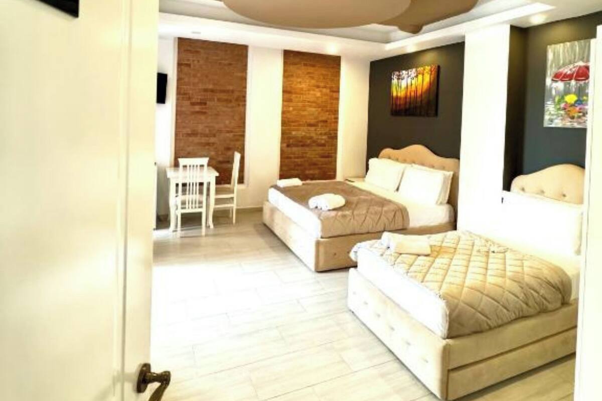 A bedroom with two beds, a desk, and a chair.