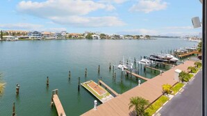 A marina with boats docked, a clear sky, and buildings in the background.