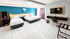 A modern hotel room with two beds, a desk, a TV, and a view of the outdoors. - IZI COZI HOTEL KEMAYORAN  (Jakarta)