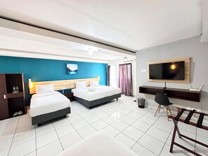 A modern hotel room with two beds, a desk, a TV, and a view of the outdoors.