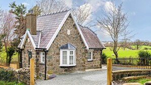 A stone cottage with a gabled roof, a chimney, and a small window. - Katie`s Cottage and Hot Tub  Snowdon 20mins drive (Snowdonia & North Wales)