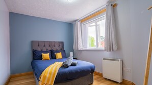 Un dormitorio con una cama, una ventana y un radiador.