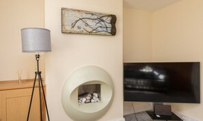A modern room with a flat-screen TV, a lamp, a fireplace, and a piece of abstract art on the wall. - Rocester Rest - Near to JCB+Alton Towers, Netflix (Alton Towers & Staffordshire Villages)