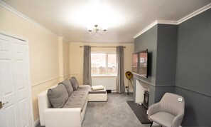 A living room with a sofa set, a television, a fireplace, and a chair. - Sherwood Pines  Big Garden (Nottingham)