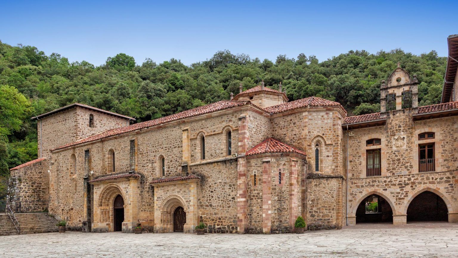 A historic stone building with multiple arches and a courtyard.