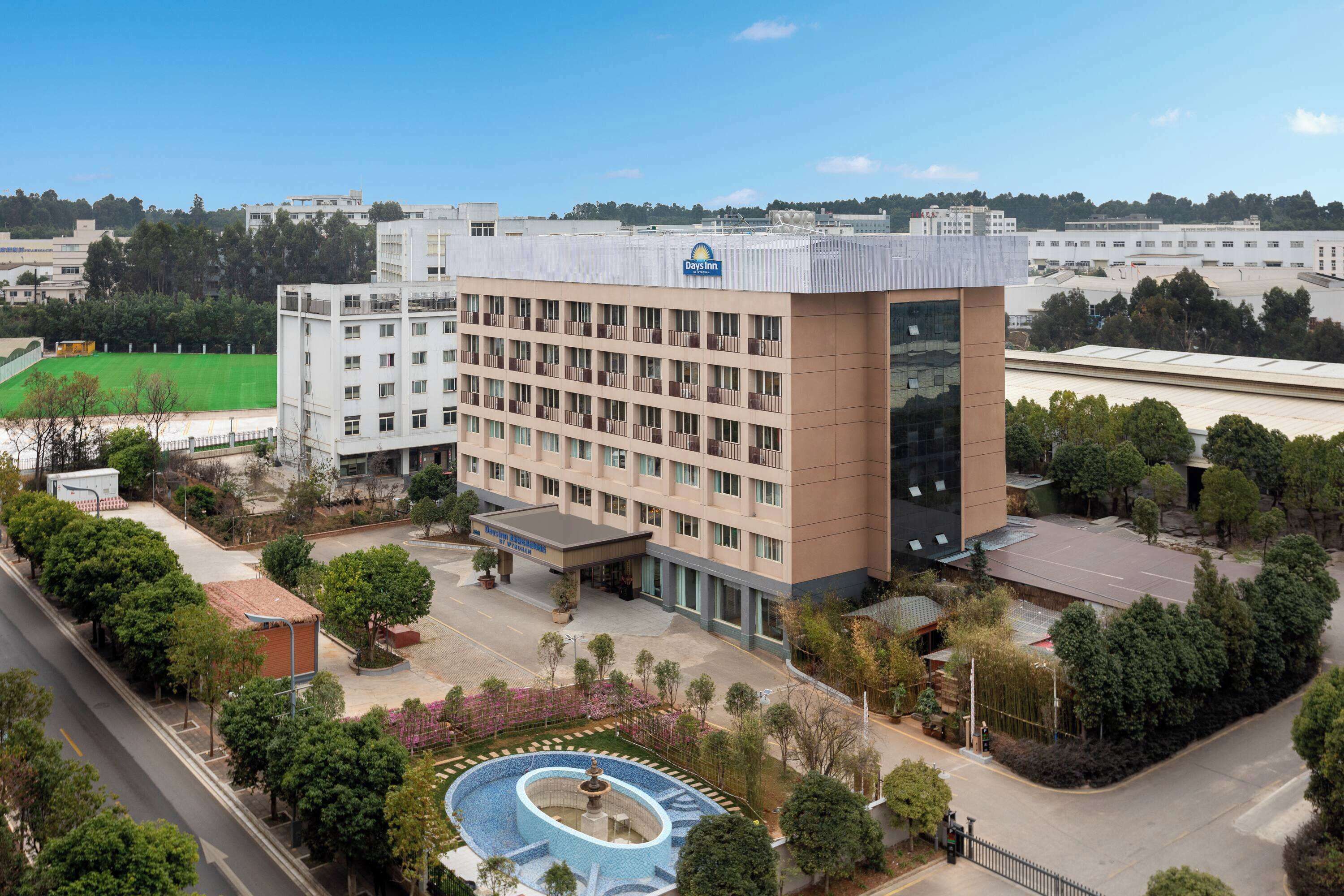 A Days Inn hotel with a central courtyard, a swimming pool, and a tennis court.
