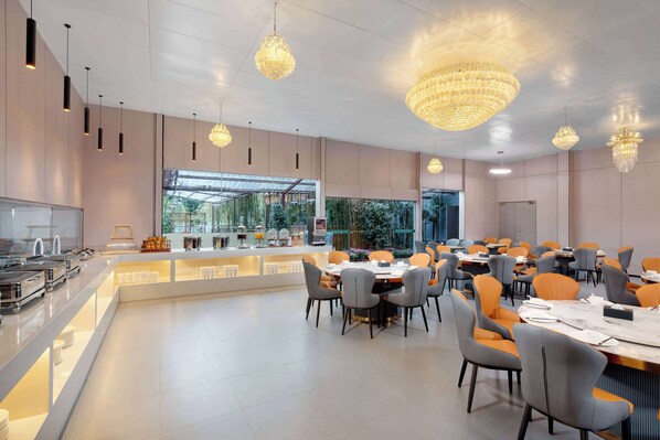 A modern dining area with a buffet, multiple tables, and chairs.