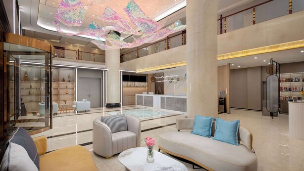 A spacious lobby with a central seating area, a reception desk, and a decorative ceiling installation. - Days Inn by Wyndham Kunming Airport Economic Zone (Kunming)