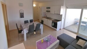 A compact living space with a dining area, kitchenette, and a balcony. - Cozy Sea View Apartments Cora 1 (Novalja)