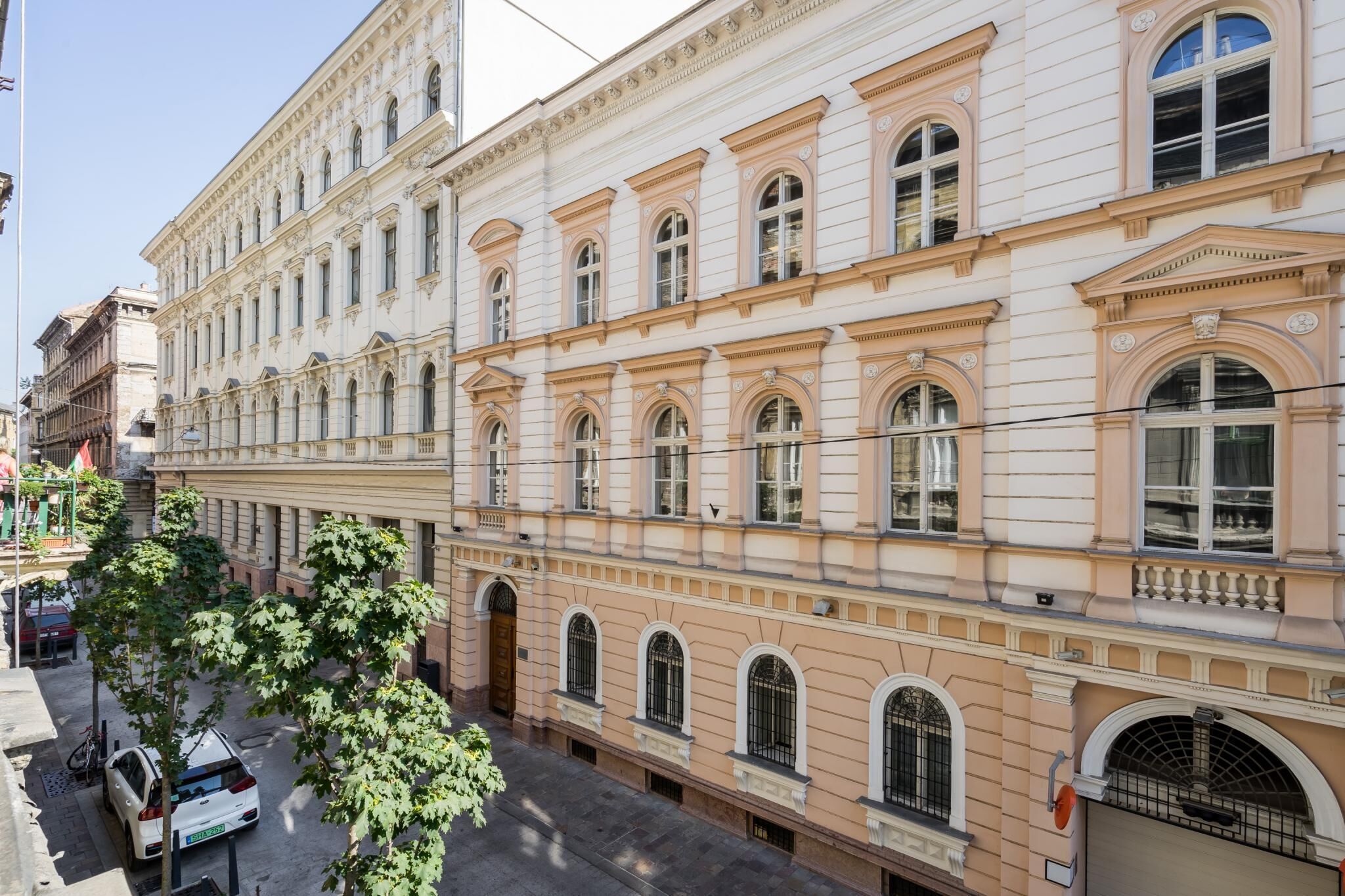 A multi-story building with classical architecture, featuring arched windows and decorative moldings.