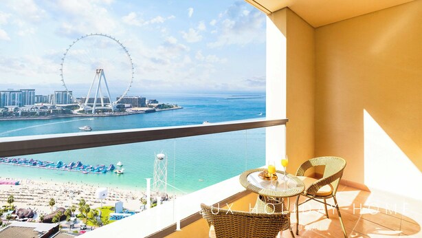 A balcony with a view of a Ferris wheel, beach, and water. - LUX The JBR BlueWaters View Suite 2 (Dubai)