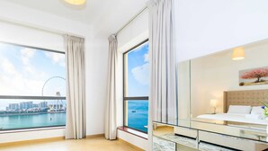 A modern hotel room with large windows offering a view of a cityscape and a Ferris wheel. - LUX The JBR BlueWaters View Suite 2 (Dubai)