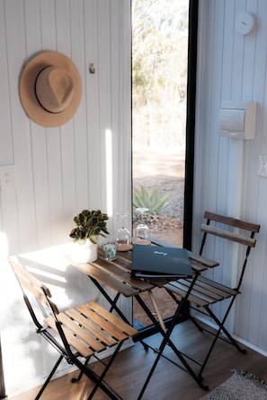 Work or unwind in this stylish space with a compact desk, potted plant, and comfortable chair.