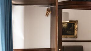 A wooden wardrobe with a coat rack, a small black radio, and a framed picture on the wall. - Affittacamere Le Dimore del Riccio (Foggia)