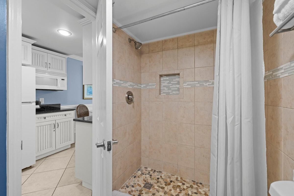 A bathroom with a shower, a toilet, and a sink.