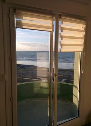 Enjoy the ocean view from the room's large window, which offers a view of the beach and the sea.