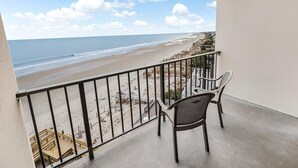 Un balcon avec vue sur une plage et l’océan.