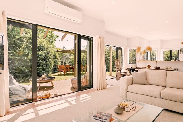 A modern living room with a large sliding glass door leading to a patio area.