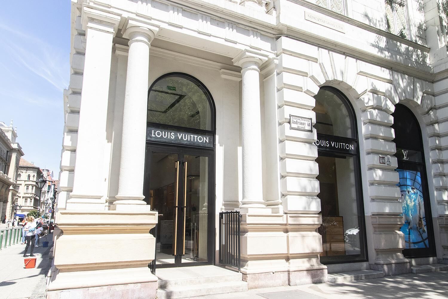 A Louis Vuitton store with classical architecture, featuring large arched windows and a prominent entrance.