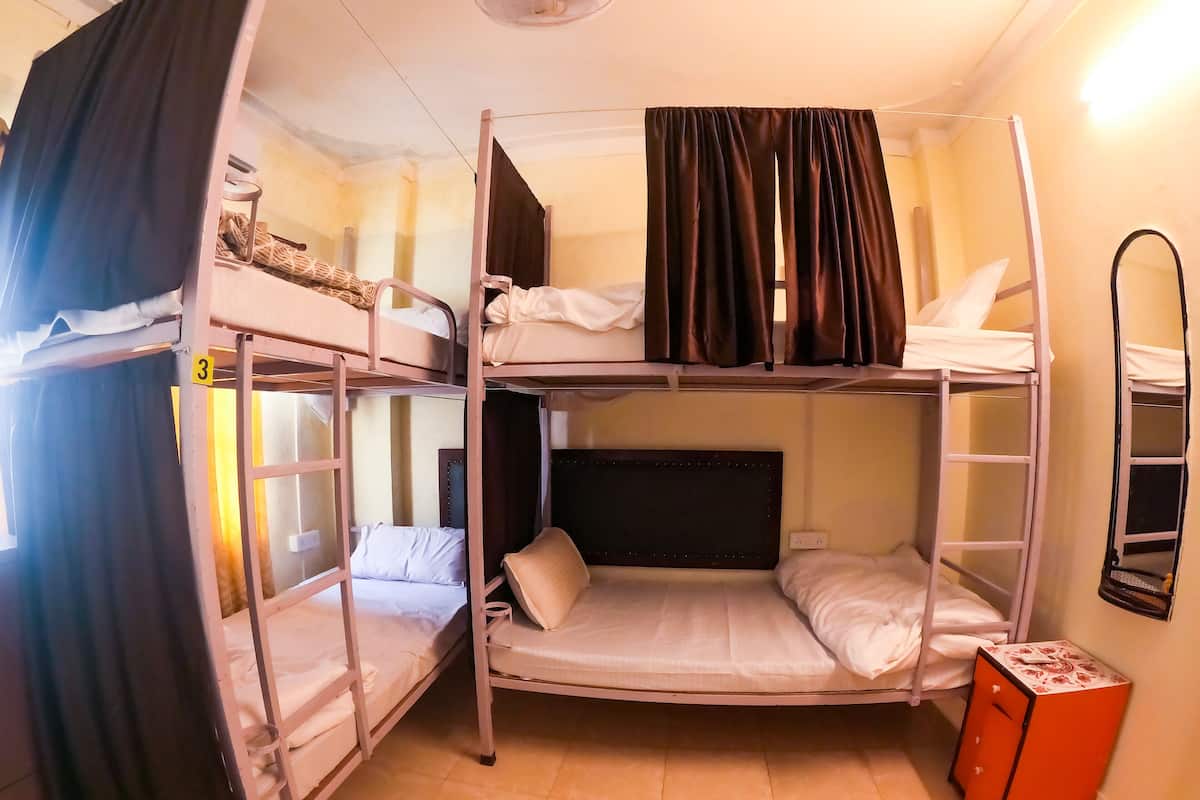 Un dormitorio con literas, una mesita pequeña y un espejo.