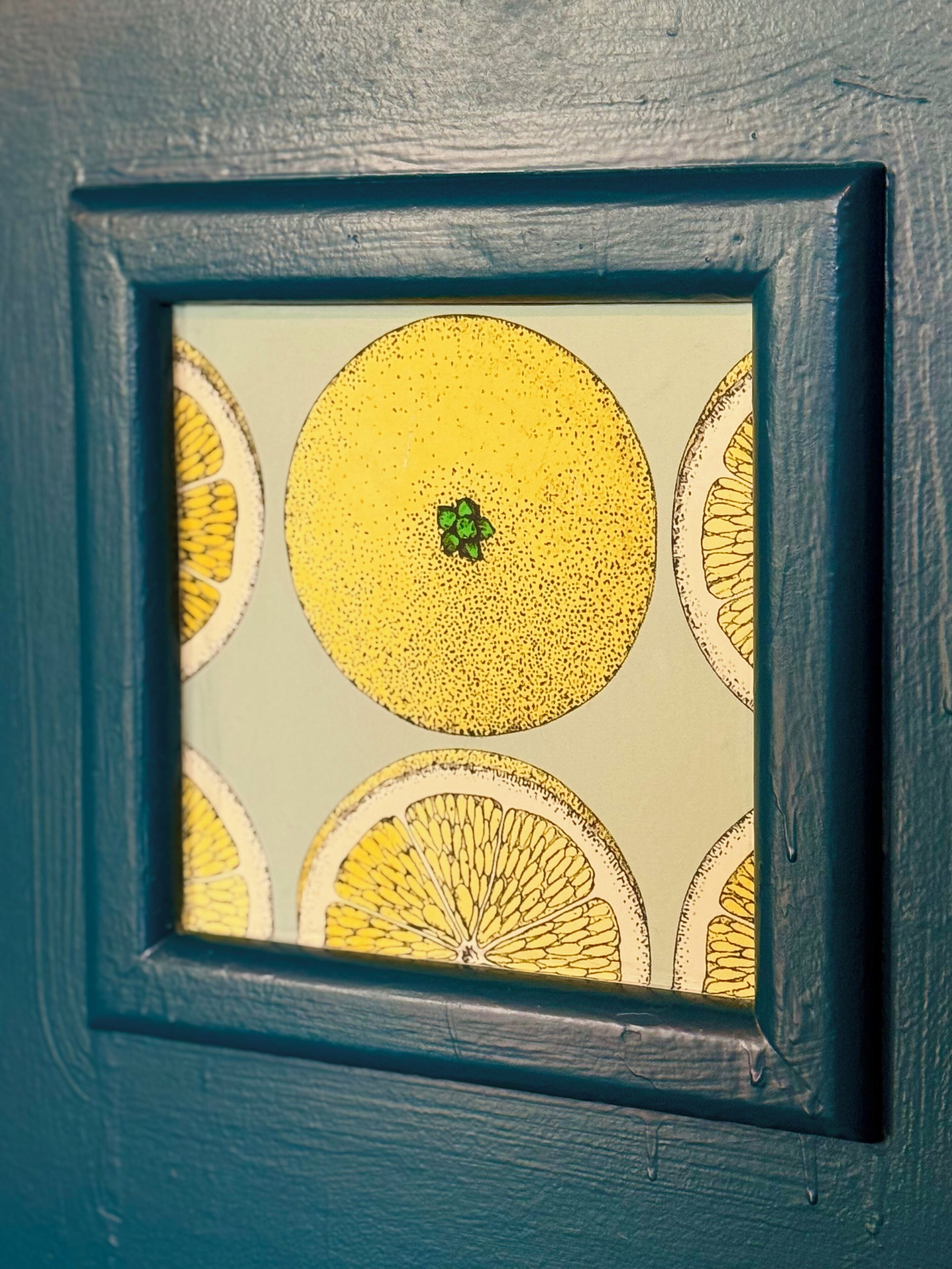 Una obra de arte enmarco que muestra naranjas sobre un fondo con textura.