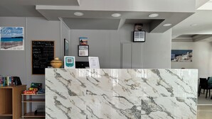 A reception desk with a marble top, a wooden bookshelf, and a chalkboard menu. - Simple Hotel Hersonissos Sun (Hersonissos)