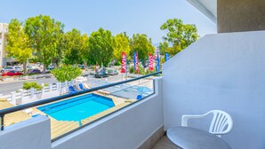 A balcony with a view of a swimming pool, a white chair, and a railing. - Simple Hotel Hersonissos Sun (Hersonissos)