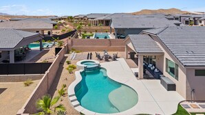 A residential area with modern houses, a swimming pool, and outdoor seating areas.