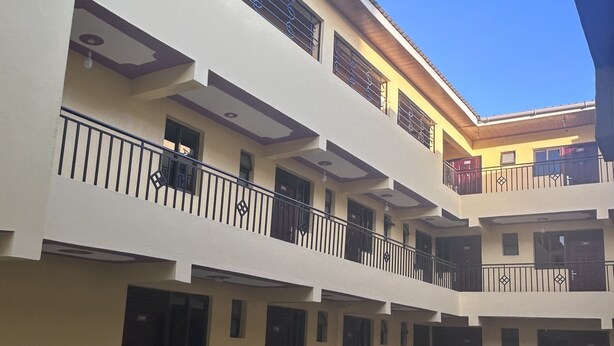 A multi-story building with balconies, a flat roof, and a clear sky. - 020-22Airbnbs (Thika)