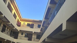 A multi-level atrium with balconies and railings, under a clear sky. - 020-22Airbnbs (Thika)
