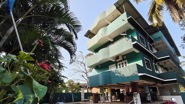 A multi-story building with a swimming pool surrounded by tropical plants. - Jungle by sturmfrei Vagator (Vagator)