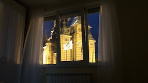 A room with a large window overlooking a historic building at night. - Joy City Stay Victoriei 7G-3 (Timișoara)