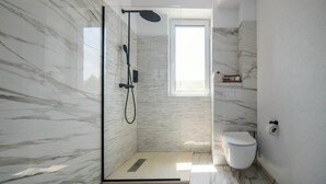 A modern bathroom with a glass-enclosed shower, a toilet, and a window providing natural light. - GBU Home - Olive Room (Timișoara)