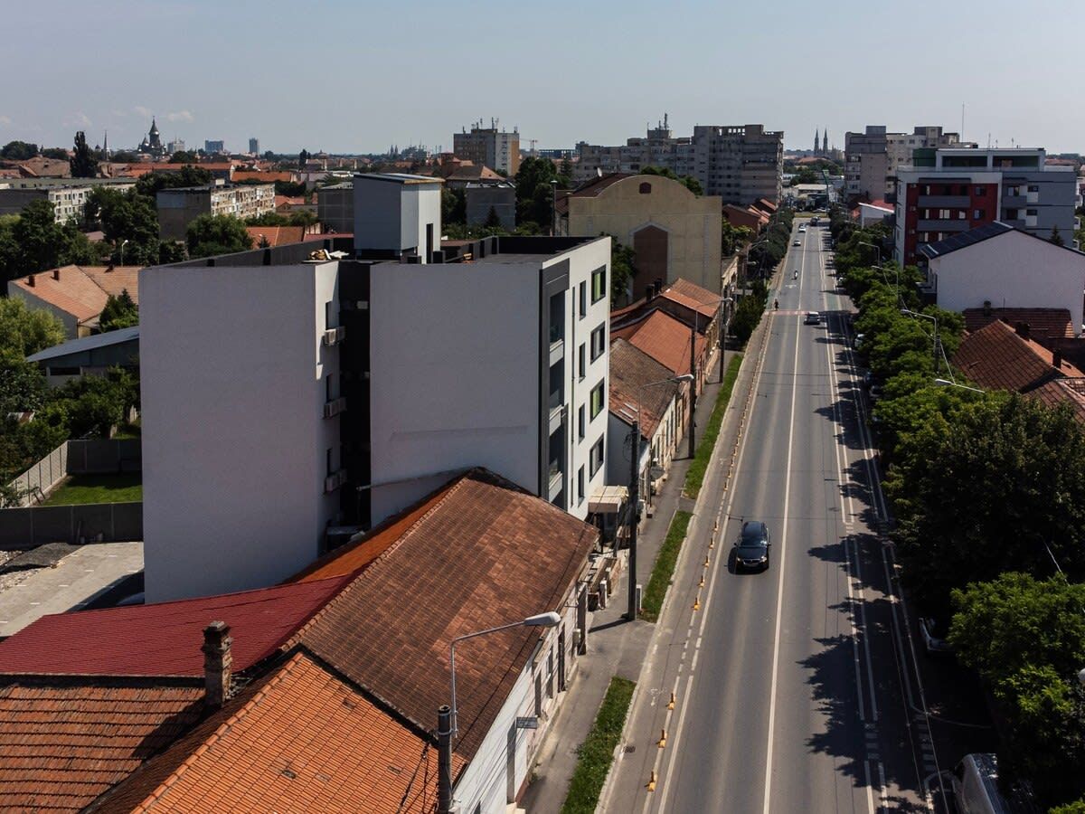 A street view with buildings, a road, and a car.
