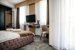 A hotel room with a bed, a desk with a flat-screen TV, a chair, and a window with curtains. - GBU Home - Pink Room 204 (Timișoara)