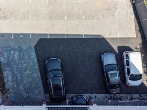 An aerial view of a parking lot with three cars parked in a row.